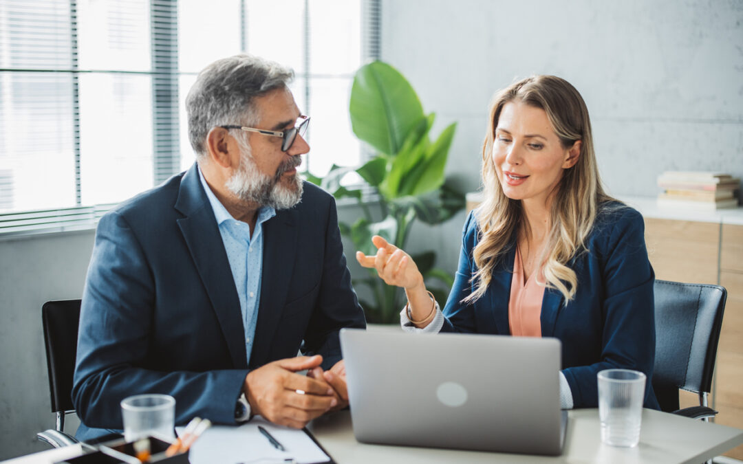 a man and woman sitting at a table with a laptop - Disaster Recovery Consulting